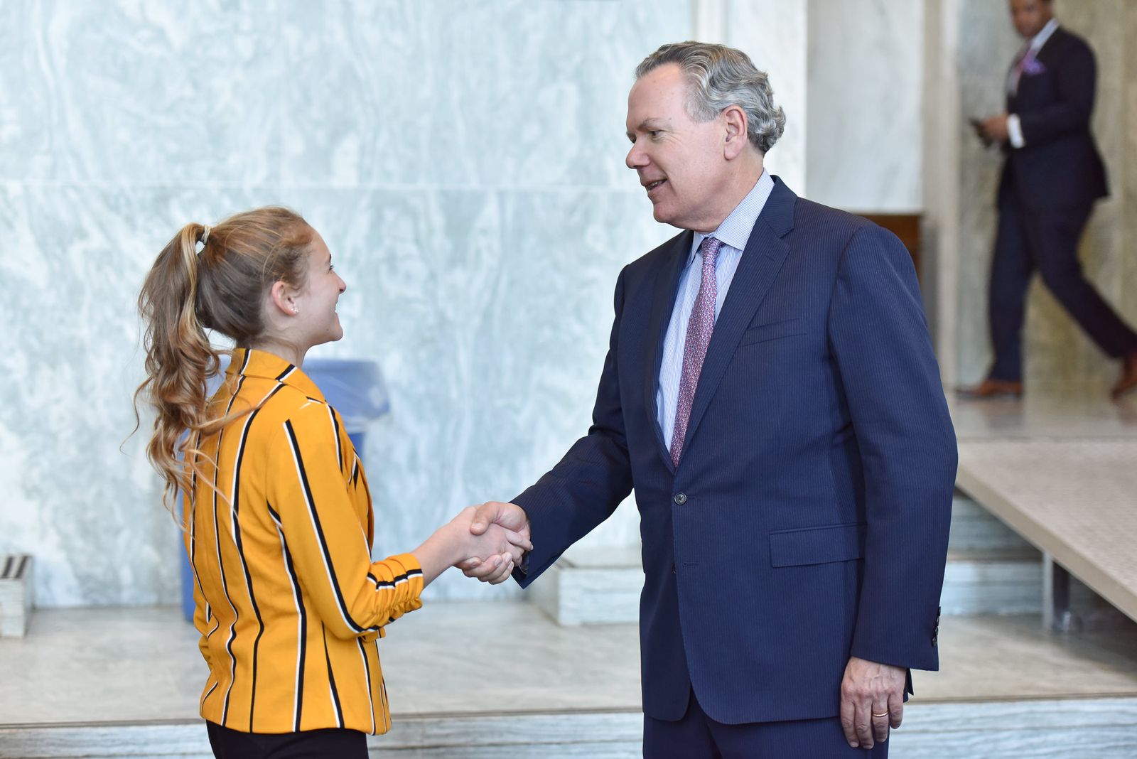 A student shakes hands with an executive on Capitol Hill