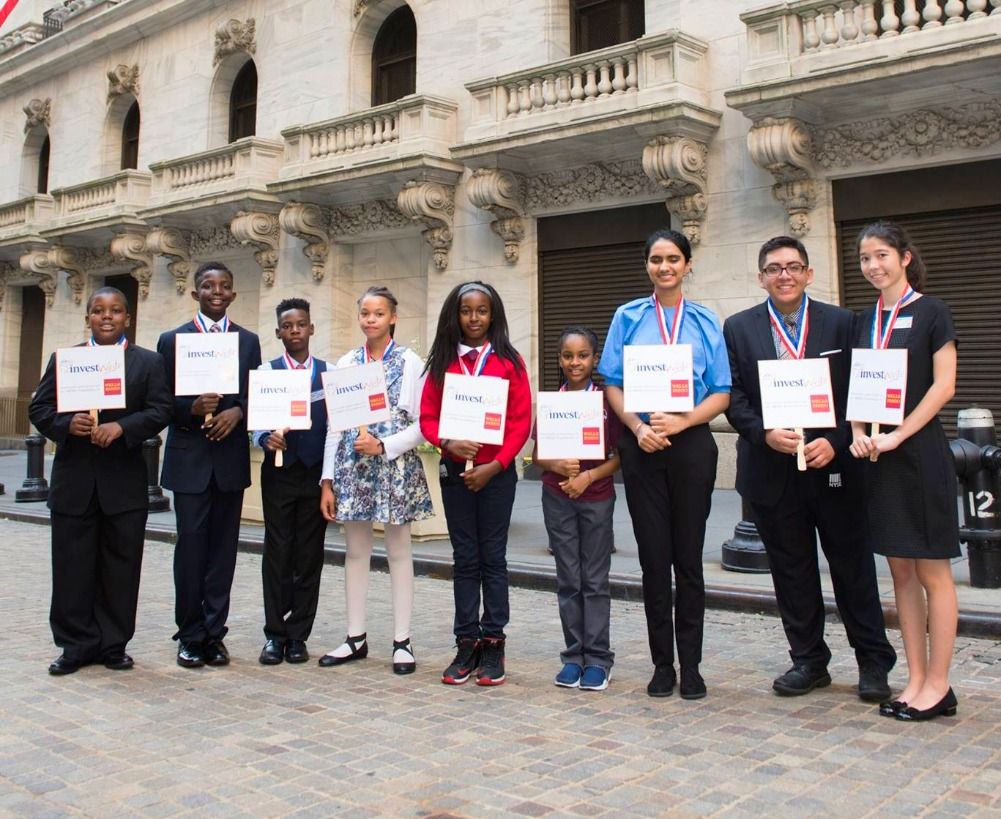 National winners with medals in front of the New York Stock Exchange
