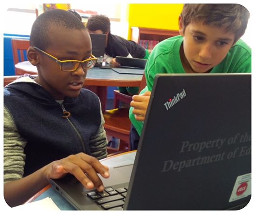 Two students researching investments on a laptop